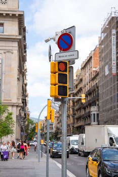 Traffic light and no parking sign on a busy street in Barcelona depicting urban life.